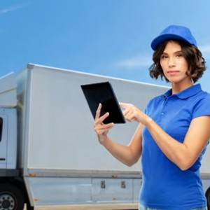 Woman holding tablet in front of truck