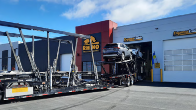 Truck loaded with cars entering a Rhyno workshop bay