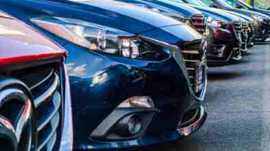 A row of cars at a used car dealership.